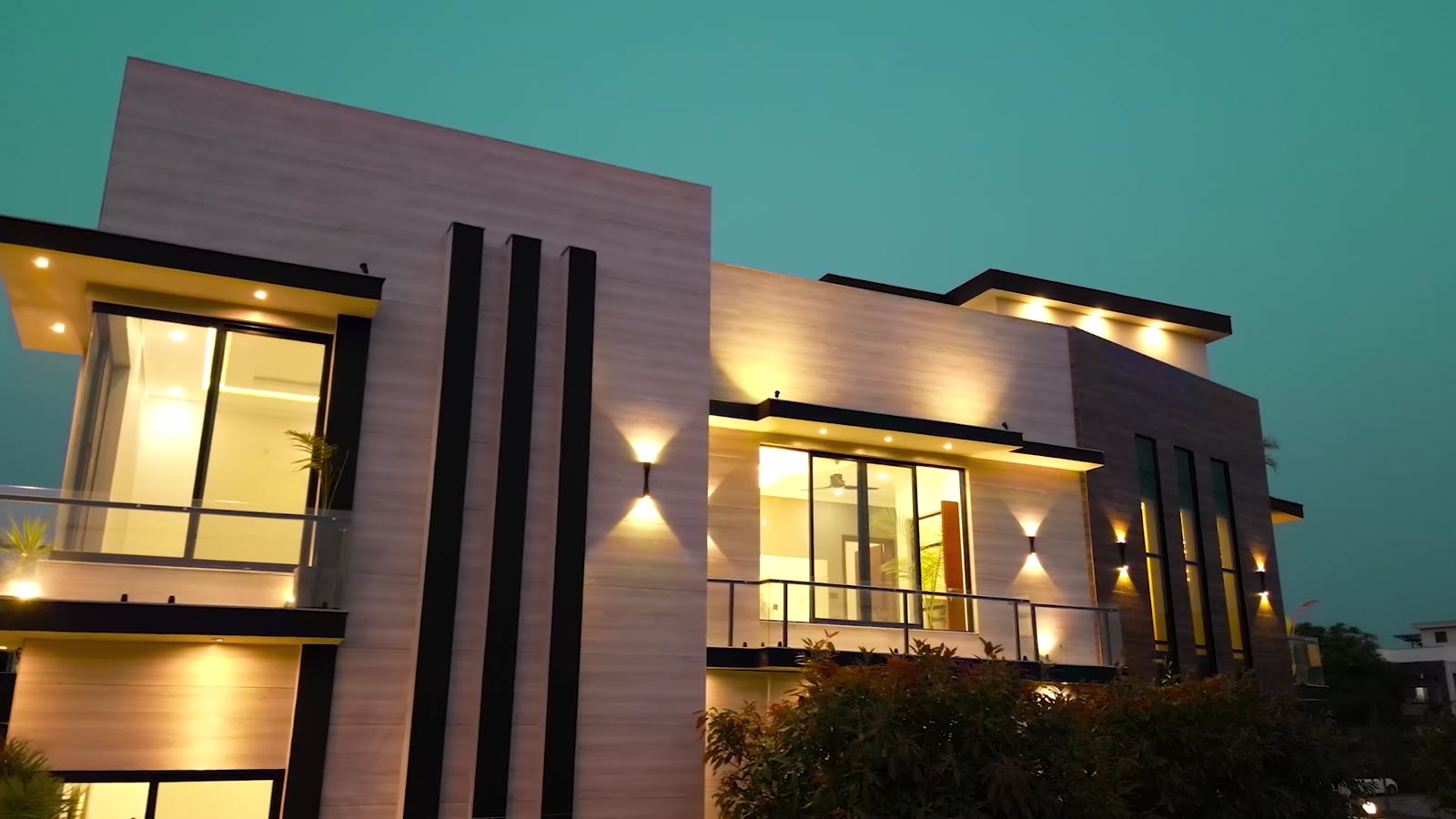 Three black vertical fins on the pale stone facade at dusk